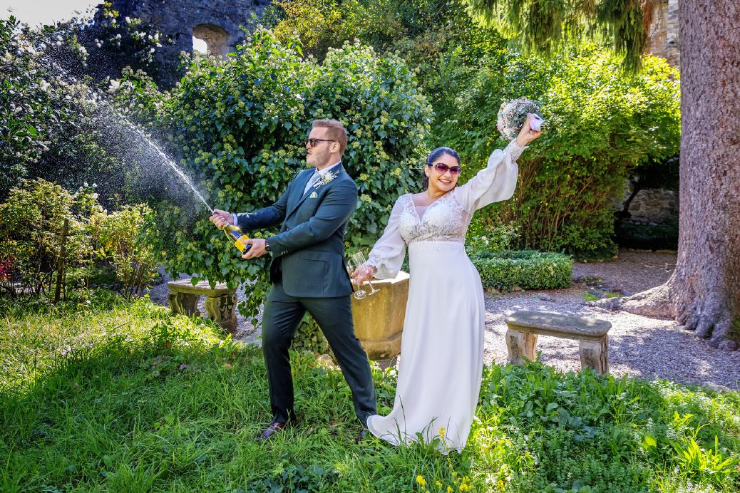 Hochzeitspaar &ouml;ffnet Champagnerflasche